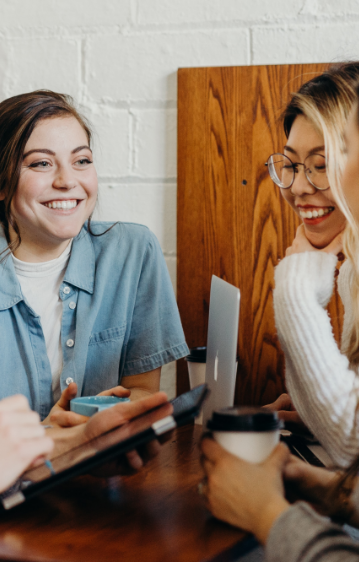 young females laughing while out for a coffee