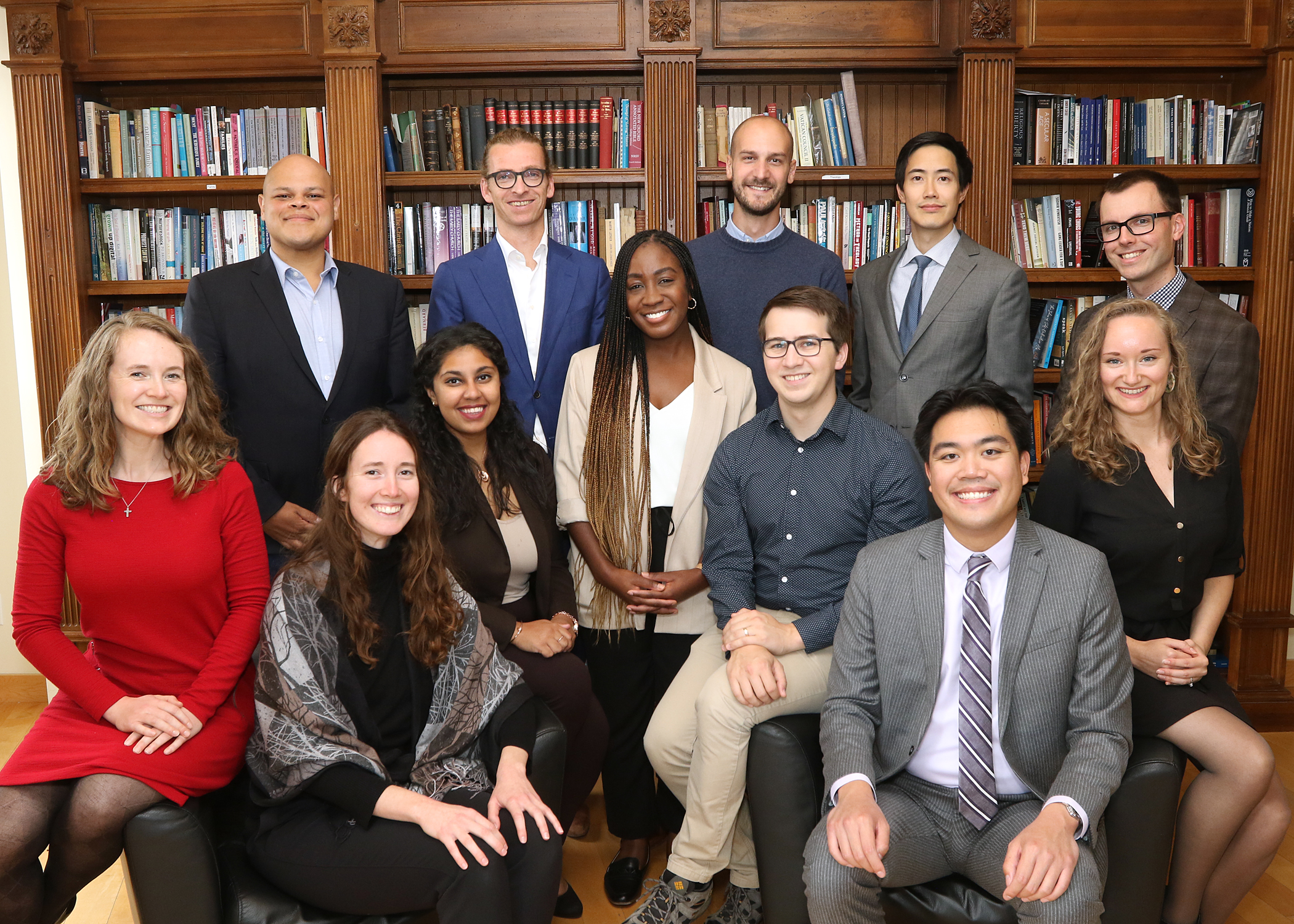 Group of diverse young professionals sitting smiling facing the camera in a library