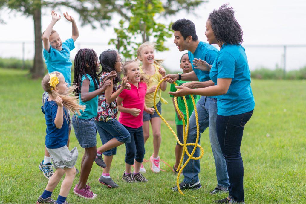 Volunteers playing with children at camp