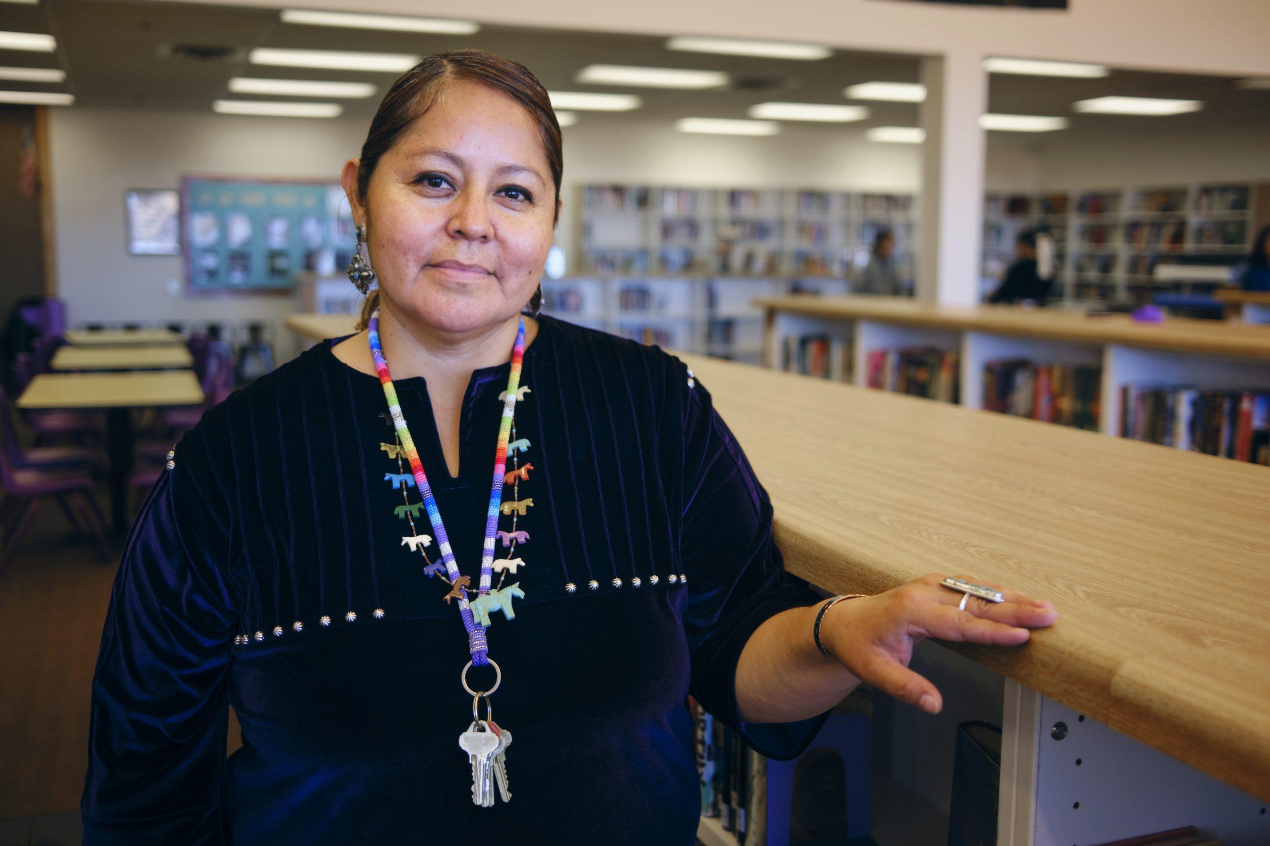 A portrait of a Native American Navajo high school teacher in a school library.