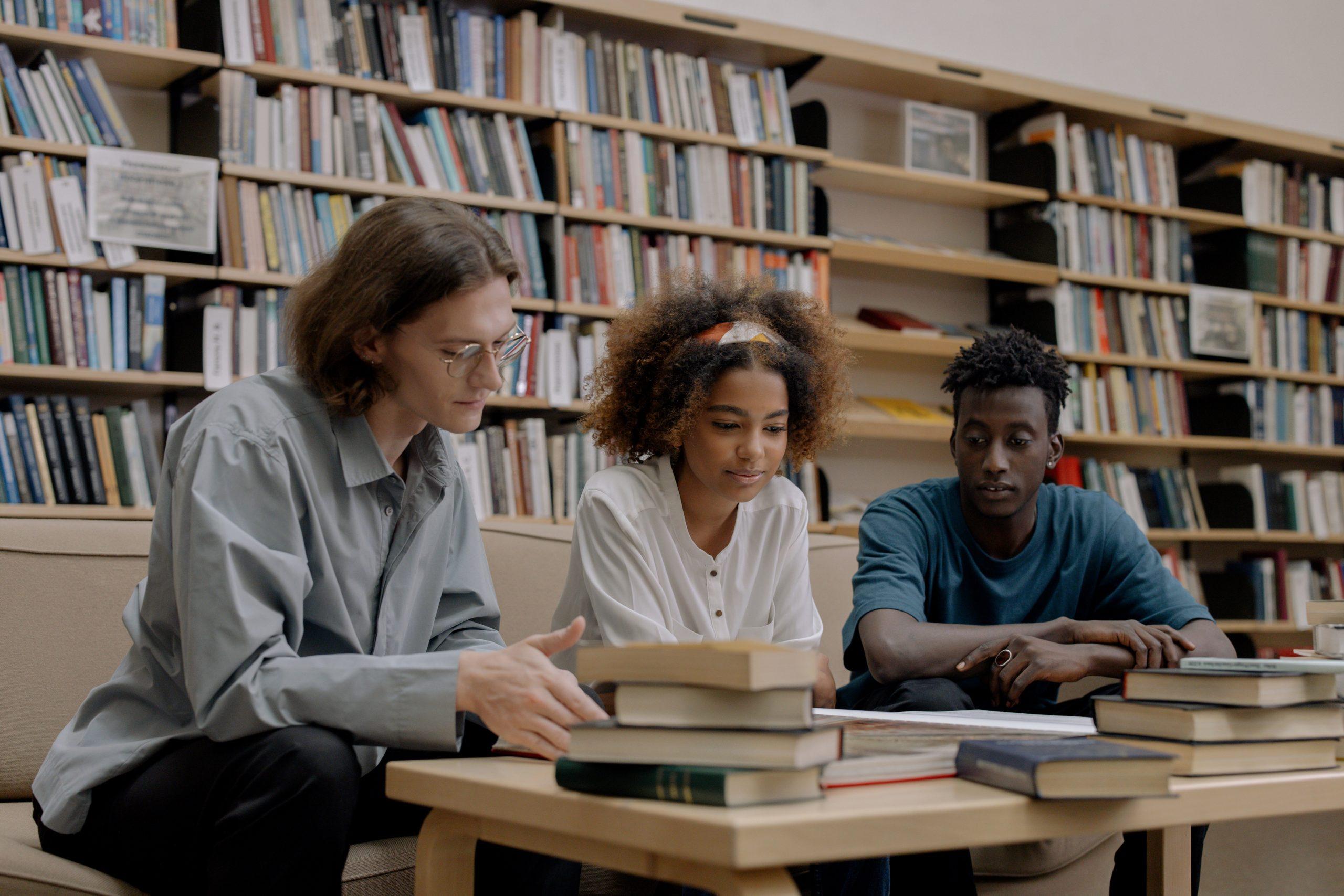 Three college students studying in a library.