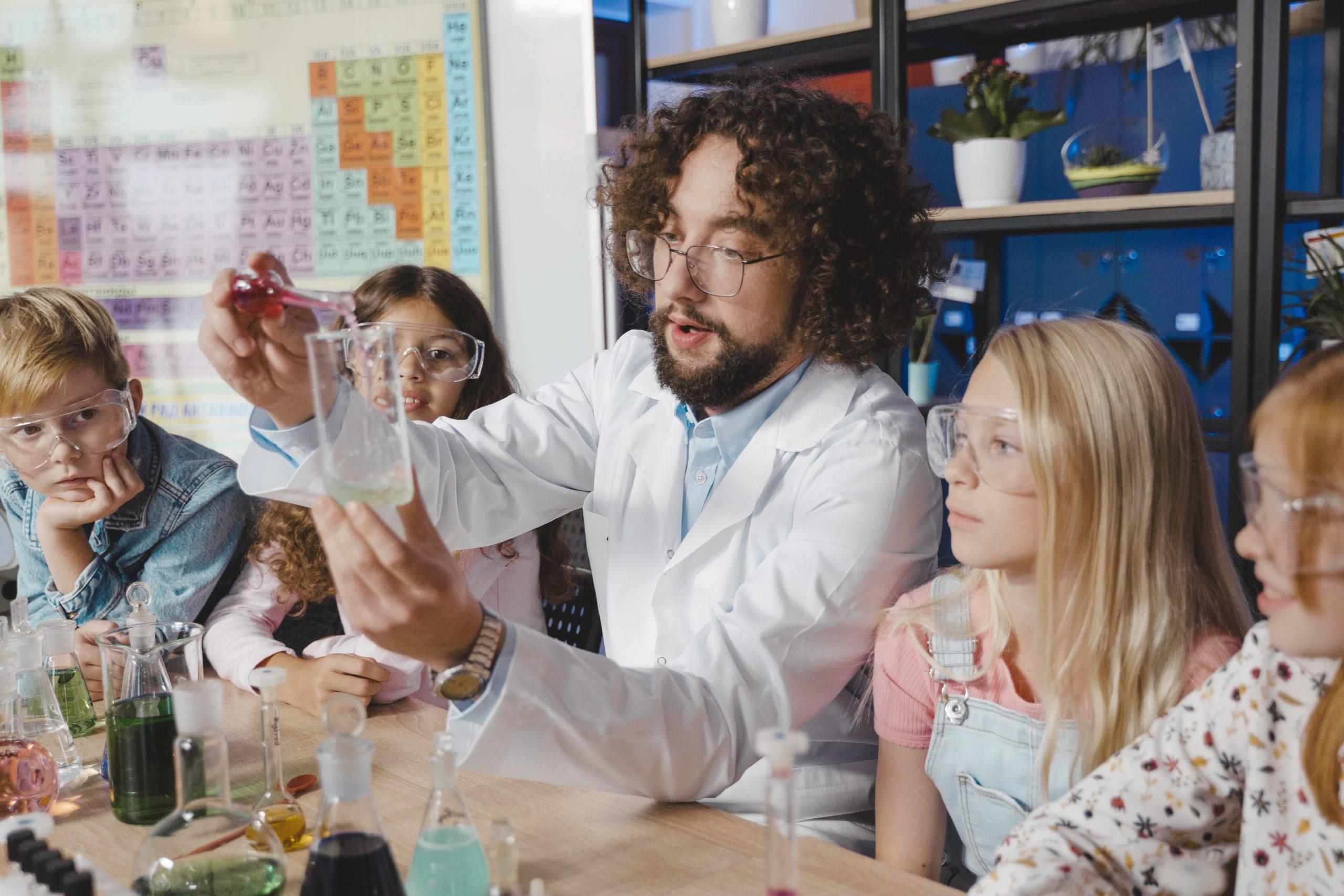 A science teacher demonstrating an experiment for his young students.