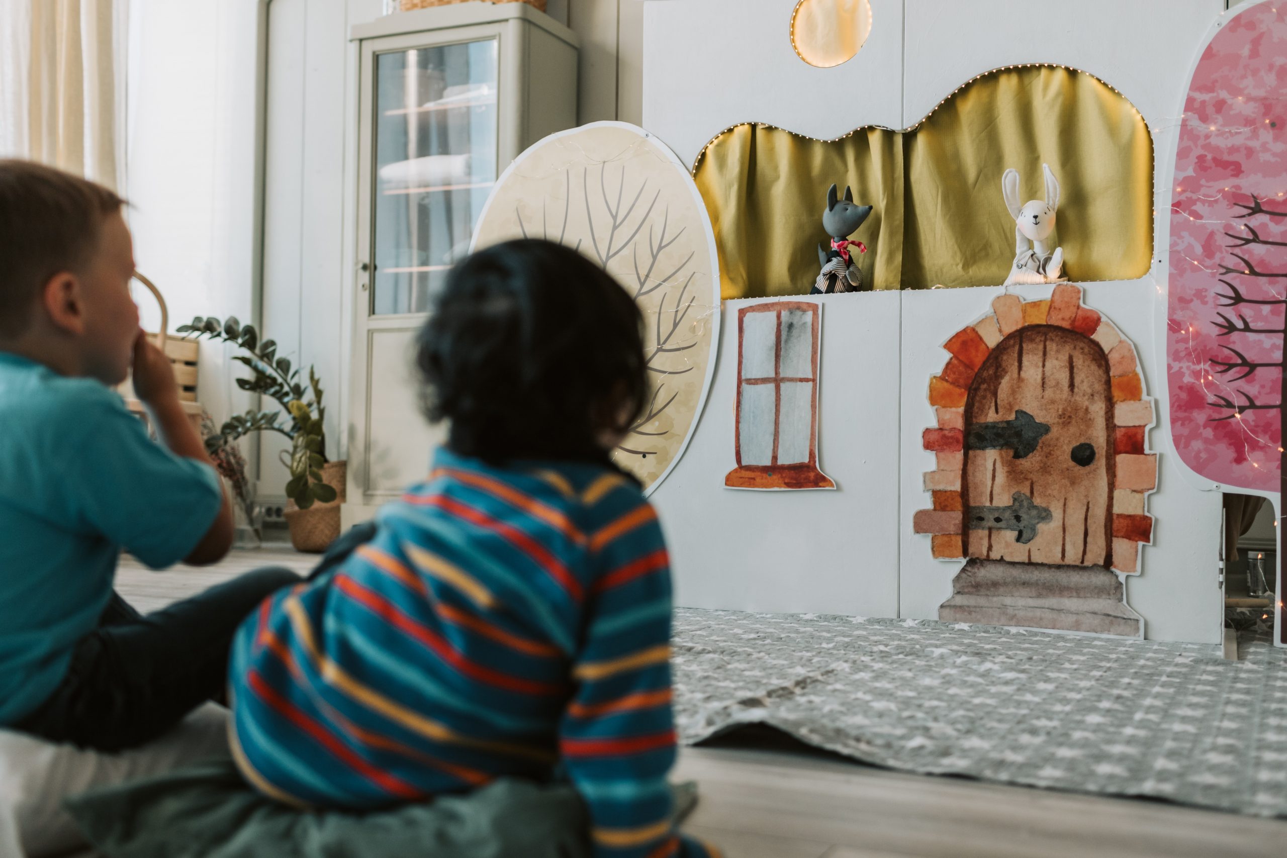 A Boy in Striped Shirt Sitting Watching a Puppet Theater