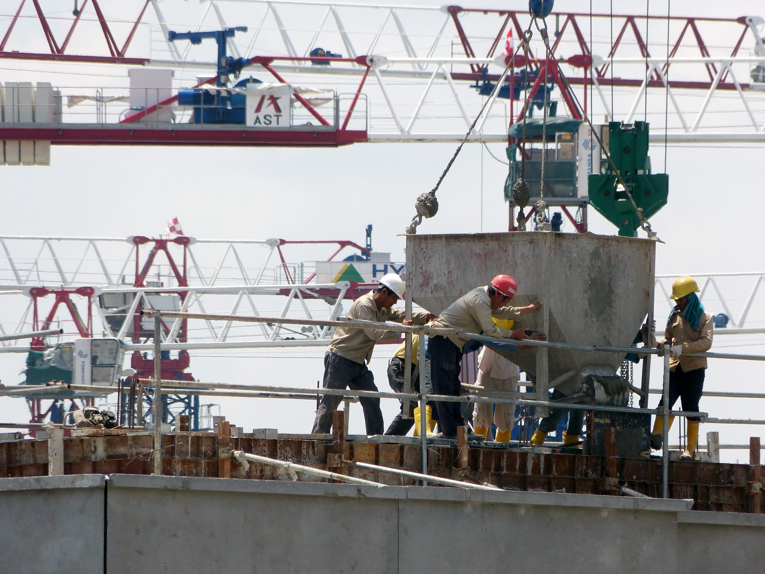 Workers filling concrete on a Highrise roof.